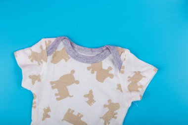 Mavi arka planda düz pamuklu bebek kıyafetleri