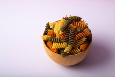 Tahta bir kase renkli spiral makarna.