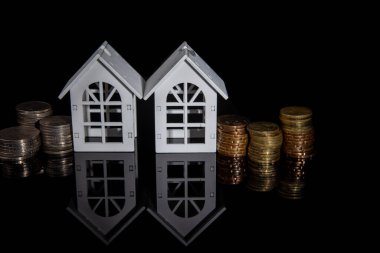 İçinde ev modeli olan bozuk para yığını ev almak için para biriktiriyor. Gayrimenkul yatırımı finansman ve bankacılık