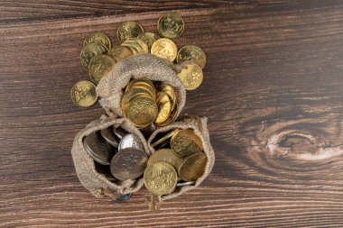 Tahta masa üzerinde Malezya Ringgit madeni para dolu çuval.