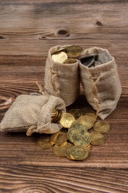 Tahta masa üzerinde Malezya Ringgit madeni para dolu çuval.