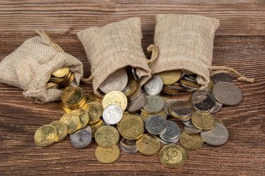 Tahta masa üzerinde Malezya Ringgit madeni para dolu çuval.