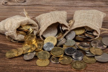 Tahta masa üzerinde Malezya Ringgit madeni para dolu çuval.