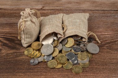 Tahta masa üzerinde Malezya Ringgit madeni para dolu çuval.