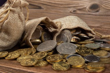 Tahta masa üzerinde Malezya Ringgit madeni para dolu çuval.