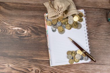 Para çantası ve boş not defteri ahşap masaya kaydedilecek - Tasarruf kavramı.