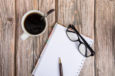 Not defteri, Gözlük, kalem ve bir fincan kahve.