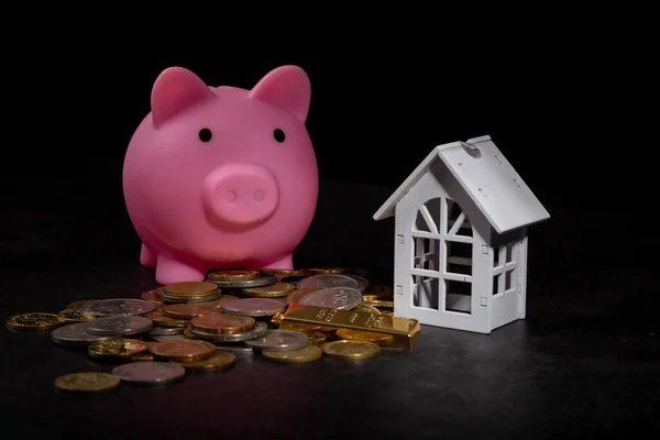 coin stack, piggy bank with house model saving money for buying house property. real estate investment finance & banking
