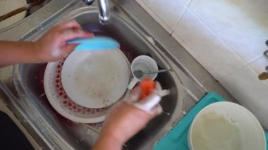 Kota Kinabalu, Sabah, Malezya - Nisan 01, 2020: Ev işi yapan adam lavaboda elleriyle bulaşık yıkıyor