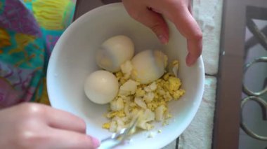 Haşlanmış yumurta kırma. Evde yemek pişirmek..