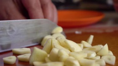 Sarımsak kesmek için bıçak kullanan bir adam.