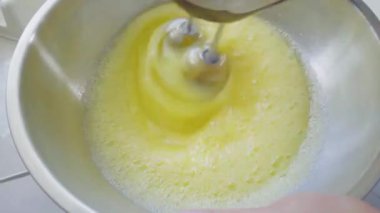 Kadınlar el çırpma makinesiyle yumurta çırpıyor..