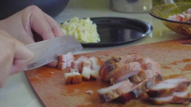 Kesme tahtasındaki Char Siew etini dilimlemek için bıçak kullanan kadın elleri görüntüsü.