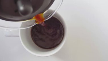 Sabahın görüntüsü kahve bardağa dökülüyor.