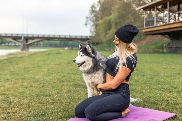 Fitness girl exercising with dog husky