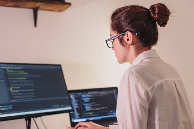 Programcı kız bilgisayarda çalışıyor. Kadınların elinden bilgi teknolojisi. Kadınlar iş başında. Kız evden çalışıyor..