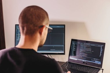 Gözlüklü bilgisayar programcısı. Bilgi Teknolojisi. Kadınlar iş başında. Adam evden çalışıyor..
