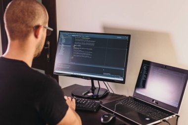 Gözlüklü bilgisayar programcısı. Bilgi Teknolojisi. Kadınlar iş başında. Adam evden çalışıyor..