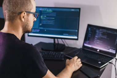 Gözlüklü bilgisayar programcısı. Bilgi Teknolojisi. Kadınlar iş başında. Adam evden çalışıyor..
