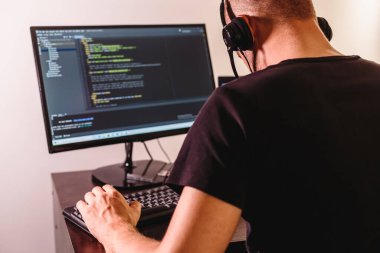 Gözlüklü bilgisayar programcısı. Bilgi Teknolojisi. Kadınlar iş başında. Adam evden çalışıyor..