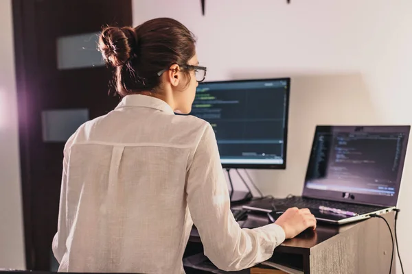 The programmer girl works at the computer.  Information technology by the hands of women. Women in business. The girl works from home.