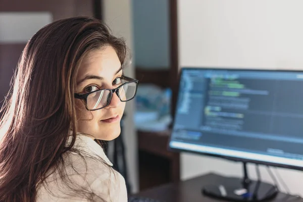 The programmer girl works at the computer.  Information technology by the hands of women. Women in business. The girl works from home.