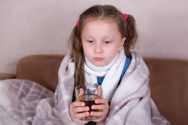 Niño tomando medicamentos. Chica enferma con bufanda acostada en la cama —  Fotos de Stock