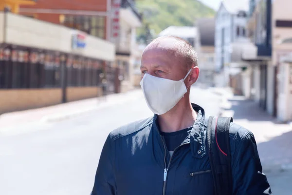 A man in medical mask on the street. A man in a medical mask. Quarantine. Self isolation.