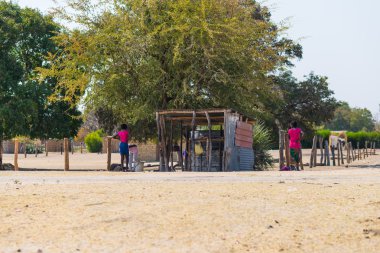 Caprivi, Namibia - August 20, 2016: Poor people working in their village in the rural Caprivi Strip, the most populated region in Namibia, Africa. clipart