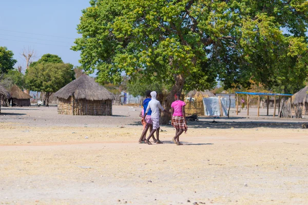Caprivi, Namibië - 20 augustus 2016: Arme tieners lopen op de weg in de landelijke Caprivi strook, de meest bevolkte regio in Namibië, Afrika. — Stockfoto