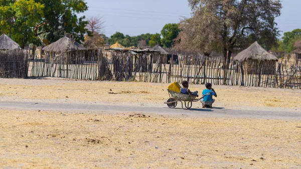 Caprivi, Namibia - 20 de agosto de 2016: Adolescentes pobres caminando en la carretera en la franja rural de Caprivi, la región más poblada de Namibia, África . — Foto de Stock