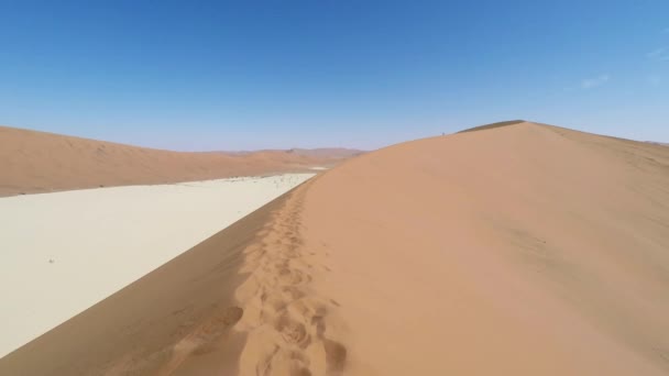 Tourist walking in the majestic Namib desert, Sossusvlei, Namib Naukluft National Park, main visitor attraction and travel destination in Namibia. Adventures in Africa. — Stock Video