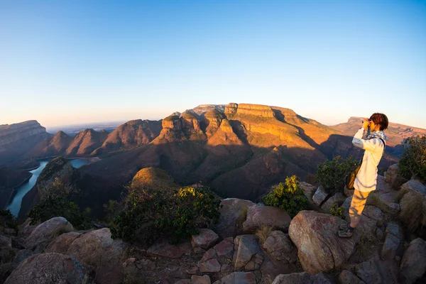 Blyde River Canyon, известный туристический маршрут в Южной Африке. Турист смотрит на панораму с биноклем. Последний солнечный свет на хребтах гор. Рыбий глаз искаженный вид сверху . — стоковое фото