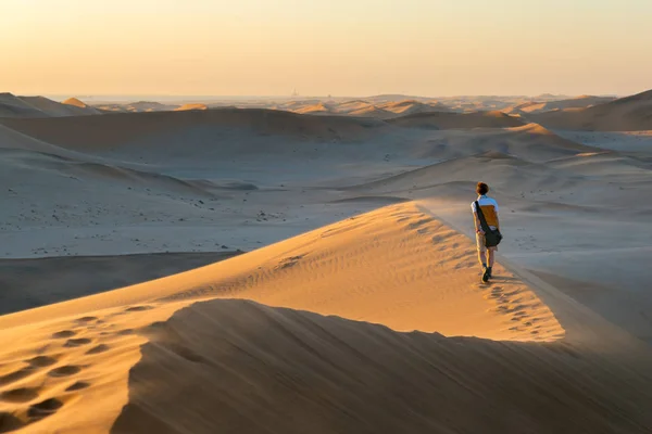 Tourist walking on the scenic dunes of Sossusvlei, Namib desert, Namib Naukluft National Park, Namibia. Afternoon light. Adventure and exploration in Africa. — Stock Photo, Image