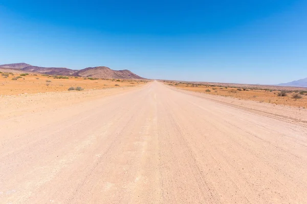 Camino de grava 4x4 que cruza el colorido desierto en Twyfelfontein, en el majestuoso Damaraland Brandberg, destino turístico escénico en Namibia, África . —  Fotos de Stock