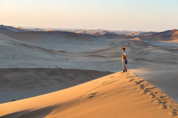 Τουριστικές περπατώντας για το γραφικό dune 7 στο Walvis Bay, έρημο Namib, εθνικού πάρκου Namib Naukluft, Ναμίμπια. Φως το απόγευμα. Περιπέτεια και εξερεύνηση στην Αφρική. — Φωτογραφία Αρχείου