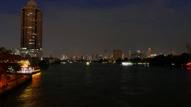 Alkonyatkor a Chao Praya folyón cirkáló hajókat. Festői megvilágított skyline a háttérben. Időközű 4k videóinak. — Stock videók