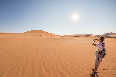 Akıllı telefon ve çekici fotoğraf Sossusvlei, Namib Çölü, Namib Naukluft Milli Parkı, Namibya, doğal kum tepeleri, holding Turizm. Macera ve keşif Afrika.