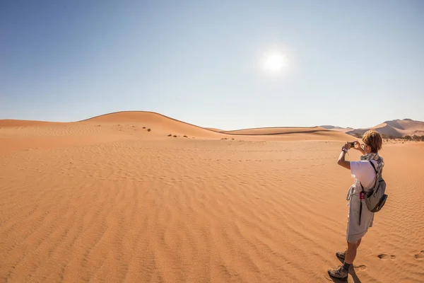 Turystycznych posiadających silny telefon i biorąc zdjęcie malowniczych wydm o Sossusvlei, pustynia Namib, Park Narodowy Namib Naukluft, Namibia. Przygody i eksploracji w Afryce. — Zdjęcie stockowe