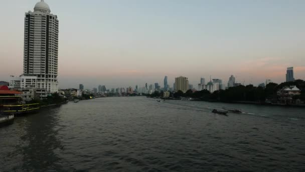 Båtar kryssning på floden Chao Praya floden i skymningen, Bangkok, Thailand. Milsvid utsikt över skyline. — Stockvideo