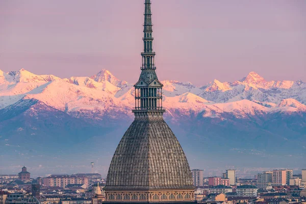 Torino (Turim, Itália): paisagem urbana ao nascer do sol com detalhes do Mole Antonelliana elevando-se sobre a cidade. Luz colorida cênica nos Alpes cobertos de neve no fundo . — Fotografia de Stock