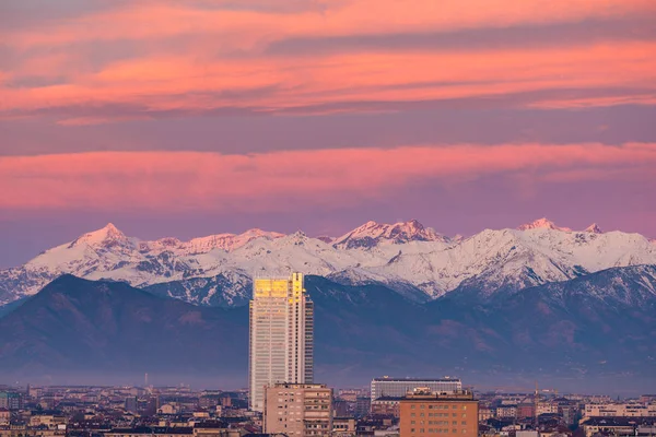 Турин (Италия): на восходе солнца над городом пролетает новый небоскреб. Сценический красочный свет на заснеженных Альпах на заднем плане . — стоковое фото