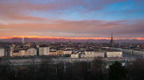 Torino (turin, italien): weitläufiges Stadtbild in der Abenddämmerung mit malerischem buntem Licht auf den schneebedeckten Alpen im Hintergrund. — Stockfoto