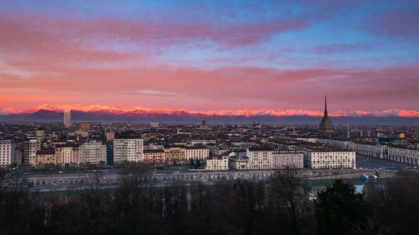 Torino (Turin, İtalya): geniş cityscape arka planda karlı Alpler'in doğal renkli ışık ile alacakaranlıkta. — Stok fotoğraf