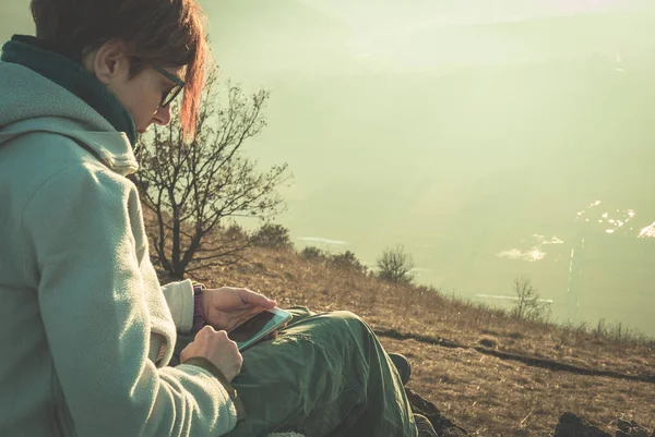 Akıllı telefon açık havada kırsal kesimde kullanan kadın. Arka yan arka ışık, tonlu görüntü vintage tarzı görünümünde. Seyahat ederken yeni teknoloji ile bilgi paylaşımı insanlar kavramı.