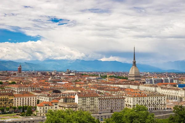 Cityscape of Torino (Turin, Italy) with the Mole Antonelliana towering over the buildings. Wind storm clouds over the Alps in the background. — Stock Photo, Image