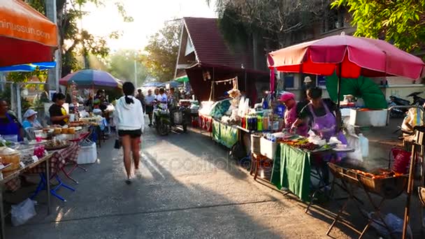 Nong Khai, Thailand - December, 2016: delicious food stall and roaming people in the colorful weekend street market at Nong Khai, Thailand. — Stock Video