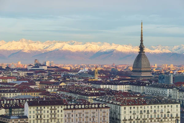 Torino (Turín, Italia): paisaje urbano al amanecer con detalles del topo Antonelliana imponente sobre la ciudad. Escénica luz colorida en los Alpes nevados en el fondo . — Foto de Stock