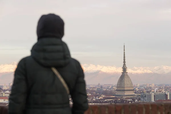 Panoramik manzaralı bir balkon yukarıdaki Torino (Turin, İtalya) bakarak turist. Kış saati, karlı Alps içinde belgili tanımlık geçmiş. Seçici odak. — Stok fotoğraf