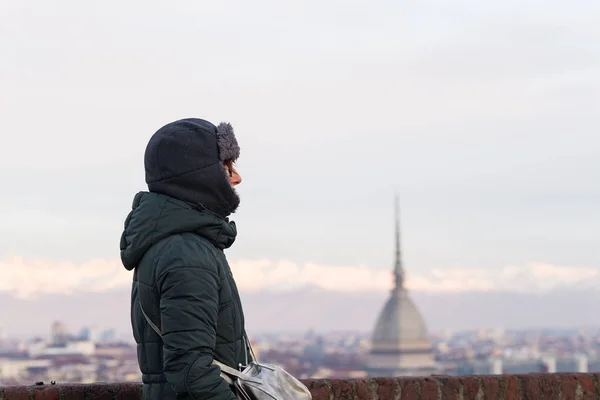 Τουρίστας βλέπει πανοραμική θέα του Τορίνο (Τορίνο, Ιταλία) από το μπαλκόνι πάνω. Χειμερινή ώρα, χιονισμένες Άλπεις στο παρασκήνιο. Επιλεκτική εστίαση. — Φωτογραφία Αρχείου